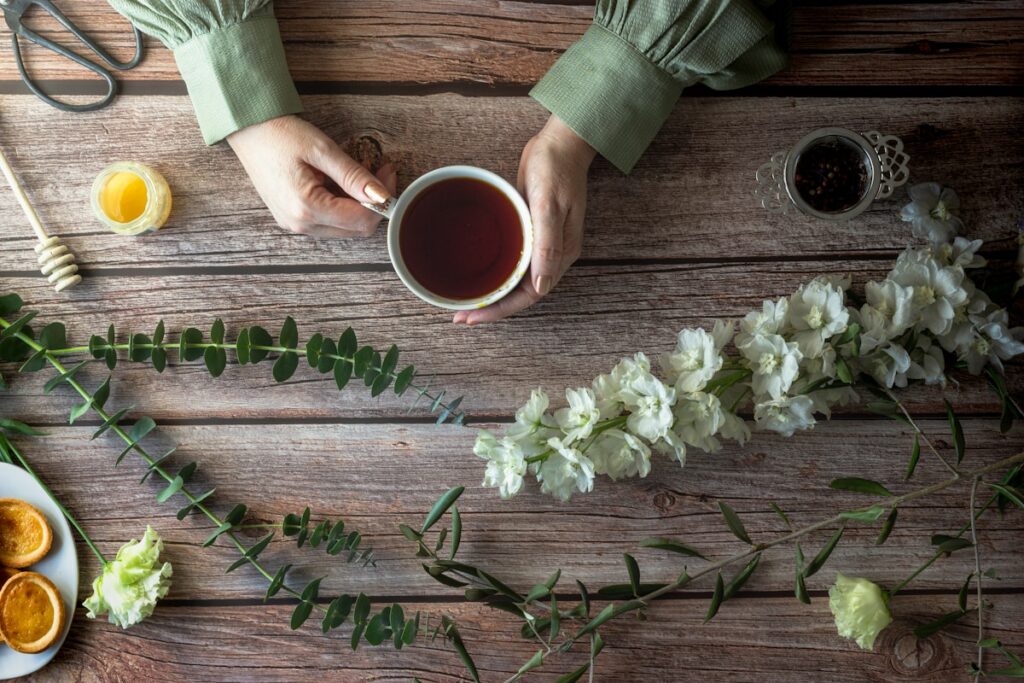 person holding white ceramic mug with brown liquid